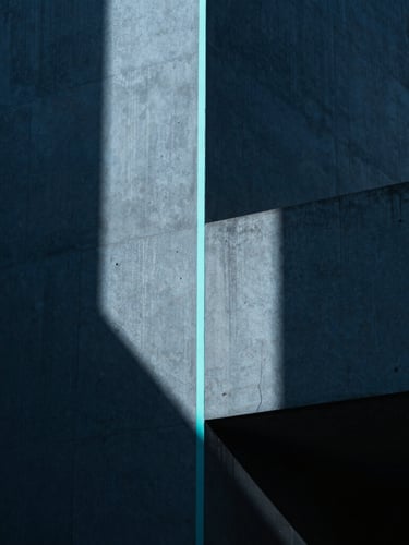 Moody architectural photography of clean minimalist concrete geometry with a sharp neon cyan light line running vertically, dramatic shadows, 35mm lens