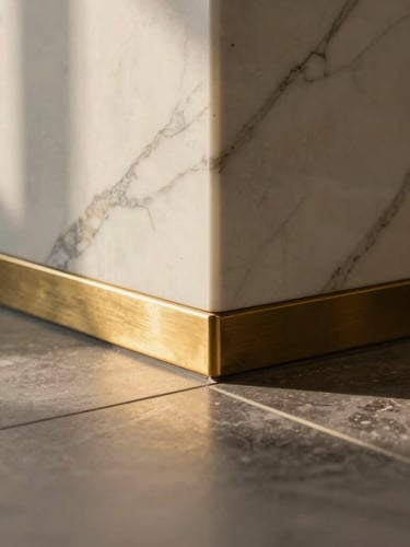 Close-up detail of a premium material junction, polished white Calacatta marble meeting a brushed brass inlay on a floor transition, sharp focus, architectural lighting.