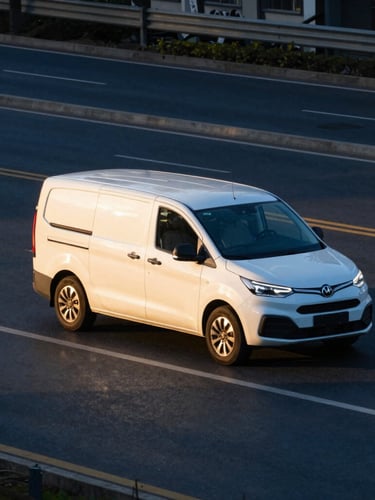 A modern white passenger car and a shuttle van driving on a clean city road during golden hour, long shadows, professional telephoto shot, sharp focus, 35mm