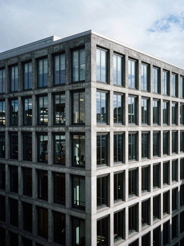 High-angle architectural shot of a modern concrete London office building under cold overcast daylight, sharp shadows, stark 35mm photography
