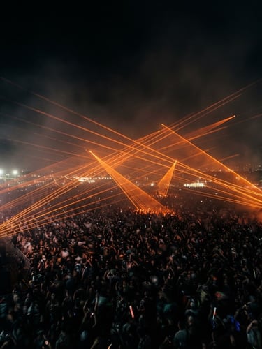 Dramatic long-exposure event photography of sharp orange laser beams cutting through a dark haze over a massive crowd, 35mm lens