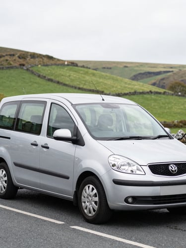 A clean modern silver taxi vehicle parked on a quiet street in Blackwood South Wales, bright overcast daylight, rolling green valley hills in the background, 35mm lens