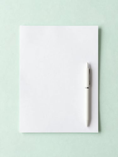 Flat-lay composition of clean white paper with gentle shadows, a minimalist pen, and a soft pastel green background, airy natural morning light