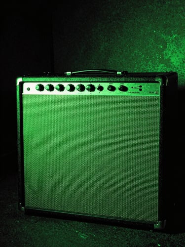 Vintage amplifier glowing in a dark basement, harsh neon green light, portrait aspect.