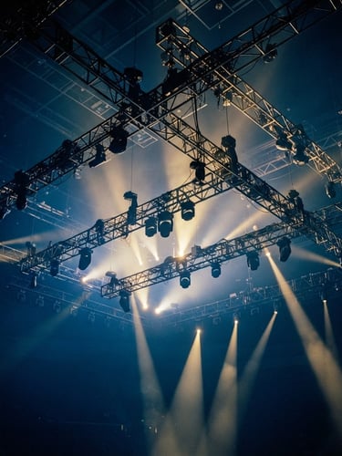 Dramatic wide-angle shot of complex overhead arena truss rigging with golden-hour stage beams slicing through deep blue haze, 35mm theatrical photography