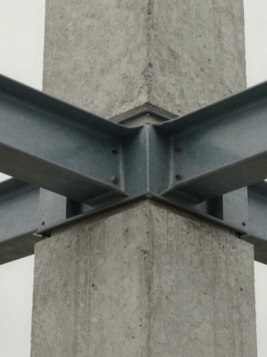 Extreme close-up of a structural concrete column intersecting with a minimalist steel frame, diffuse overcast daylight, high material fidelity.