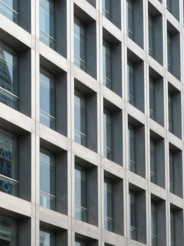 Sharp architectural close-up of a modern commercial building facade in Doha, showcasing precise steel and glass installation under bright daylight, high contrast.