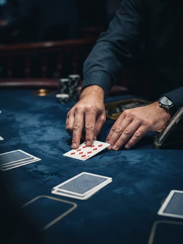Sharp editorial photography of professional hands dealing cards with absolute precision on a deep midnight blue felt table, dramatic low-key spotlight, crisp focus, 50mm.