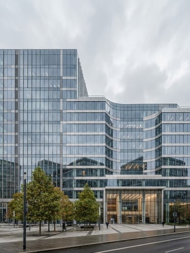Wide panoramic view of a modern corporate building facade with clean lines, reflecting an overcast sky, professional architectural photography, muted corporate tones, natural daylight.