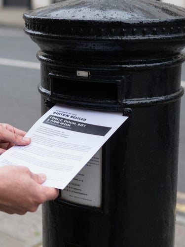 Close-up of hands delivering a high-quality printed flyer through a classic British black metal letterbox, high contrast, overcast natural daylight, desaturated urban tones, 35mm lens.