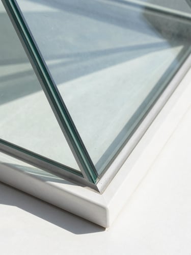 Macro architectural detail of a modernist glass prism refracting bright daylight, sharp geometric shadows, clean white and silver tones, 35mm lens.