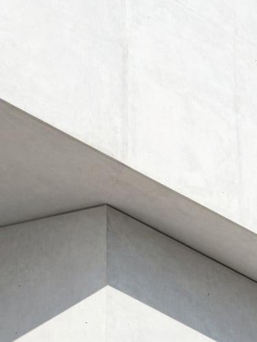 A sharp geometric concrete structure shot in bright high-key daylight, clean white and silver tones with razor-sharp shadows, minimalist architectural photography, 35mm lens