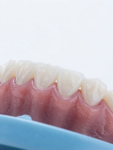 Macro photograph of healthy pink gums and clean white teeth, bright high-key clinical photography, soft white daylight, professional dental setting.