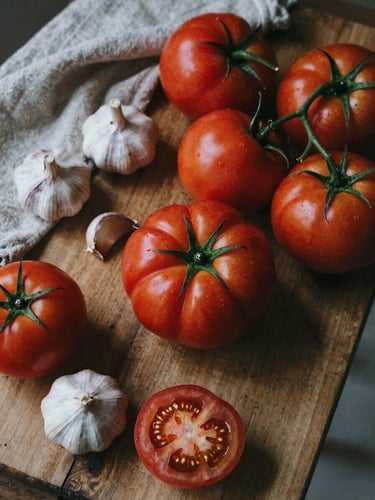 Overhead shot of a rustic wooden prep table with fresh heirloom tomatoes, garlic bulbs, and a linen cloth, soft natural Scandinavian daylight, moody shadows, rich crimson tones, 35mm film.