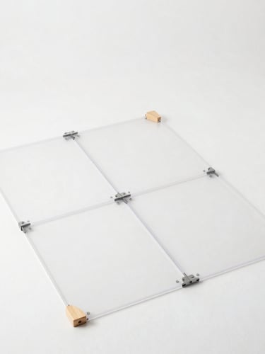 Overhead flat-lay of unassembled modular transparent playpen panels, steel connectors, and clean-sanded wooden joints on a bright white studio floor, sharp focus, crisp neutral lighting, 50mm lens