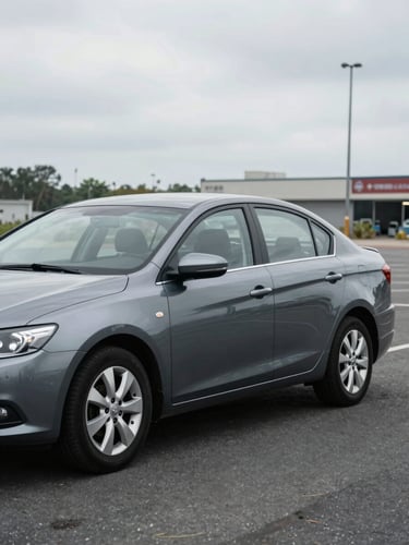 Wide daylight shot of a used sedan on an open lot, full driver-side quarter-panel view from front-left, overcast natural light, asphalt and faint lot signage visible in background, honest documentary framing with no staging