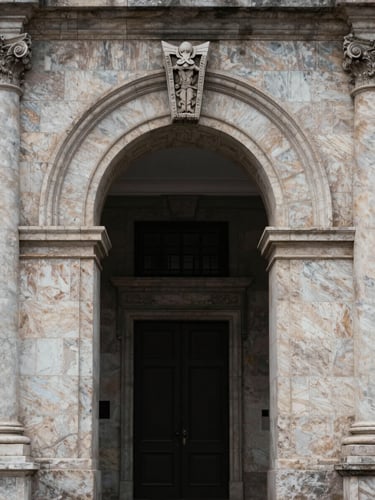 Symmetrical close-up of a hand-carved stone archway on a historic building facade, soft overcast daylight, highlighting texture and weight