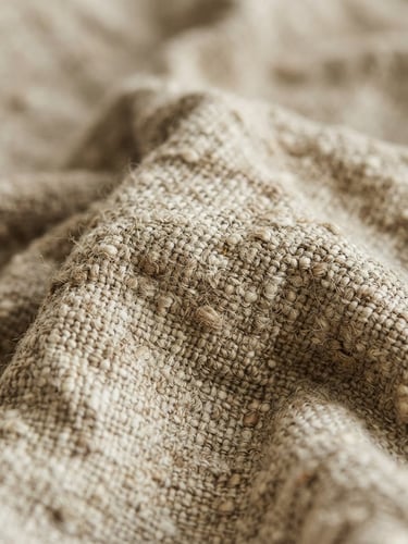 Macro close-up of heavy-weight rumpled oatmeal linen fabric, rich tactile weave texture, soft indirect morning daylight, shallow depth of field.