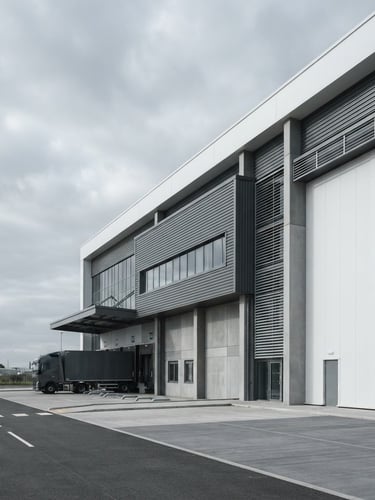 Sharp architectural crop of a modern logistics hub on the right, cool overcast daylight, desaturated corporate tones, minimalist composition, wide-angle.