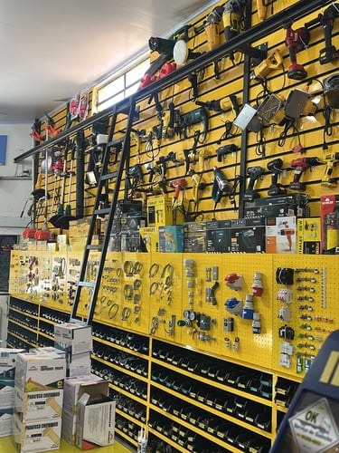 Amplo painel de exposição com ferramentas elétricas, furadeiras, roçadeiras e equipamentos manuais a