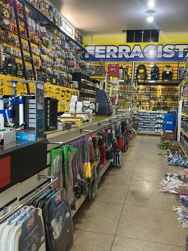 Visão interna dos corredores da Ferragista Central em Anápolis, GO, mostrando balcões e prateleiras