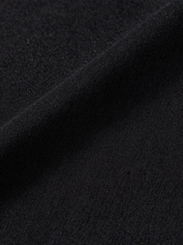 Minimalist studio macro shot of a Reserva black cotton t-shirt fabric texture, soft overhead lighting, sharp details