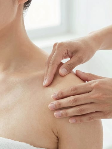 Close-up of hands-on manual therapy being performed on a patient's shoulder, bright natural daylight, clean clinical setting.