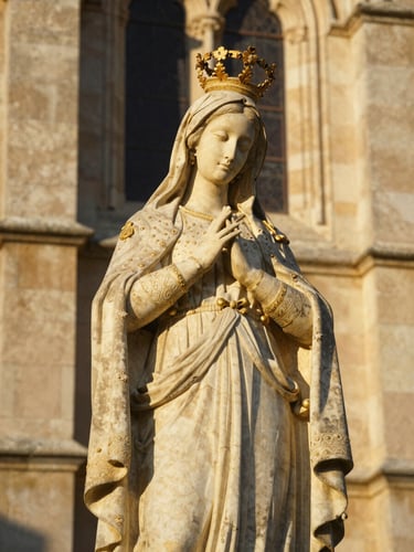 Détail de la statue de la Vierge Miraculeuse veillant du haut de la basilique de Lablachère, pierre séculaire dorée par le soleil couchant, style éditorial