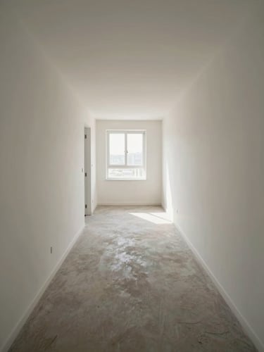 Wide shot of an empty hallway inside a managed residential property, natural window light at the far end, clean walls and flooring, environmental scale evident, no people