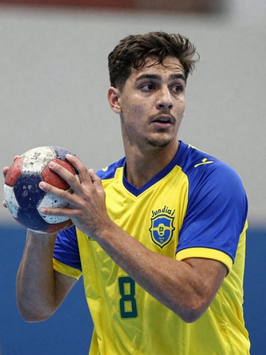 Heroic portrait of a young Brazilian handball player holding a worn leather ball under bright gym light, intense and focused expression, Jundiai team colors on jersey, high contrast, 35mm.