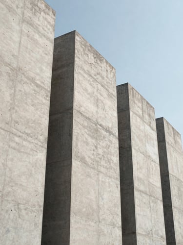 Low-angle shot looking up at massive precast concrete walls standing in precise structural alignment, sharp geometric lines against a clear sky, high-contrast natural daylight