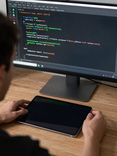 Macro over-the-shoulder shot of a developer analyzing Kotlin code on an ultra-wide monitor, subtle green rim lighting reflecting off a physical Android tablet on the desk.