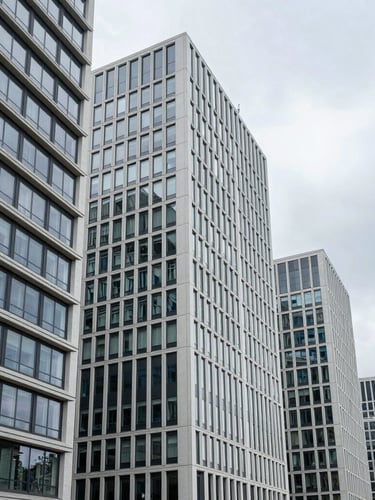 A clean, bright architectural shot of a modern European business district in daylight, sharp geometric lines, overcast sky.