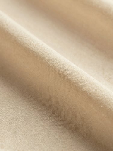 Extreme close-up of soft ivory cotton voile fabric texture, detailed weave, warm diffused light, shallow depth of field