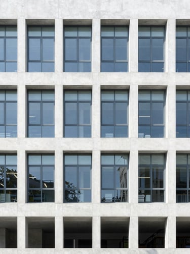 Minimalist concrete and glass university library facade, bright natural daylight, crisp white and slate gray tones, sharp focus, 35mm lens