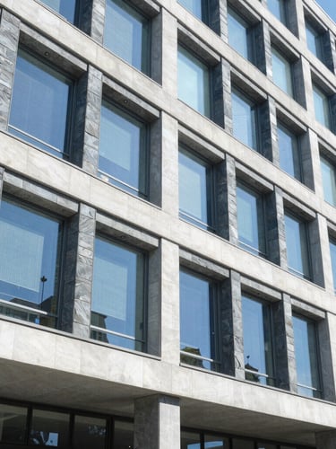 Cool architectural detail of a modern international NGO headquarters in Geneva, bright natural daylight, slate blue tones, sharp focus, 35mm lens