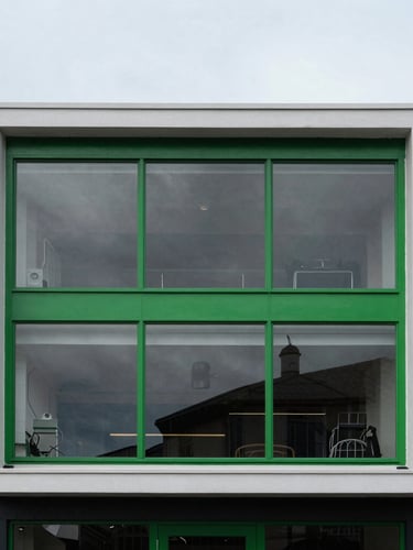 Sharp high-contrast architectural crop of our Brighton studio, cool desaturated tones with sharp green highlights, overcast coastal daylight, 35mm portrait framing