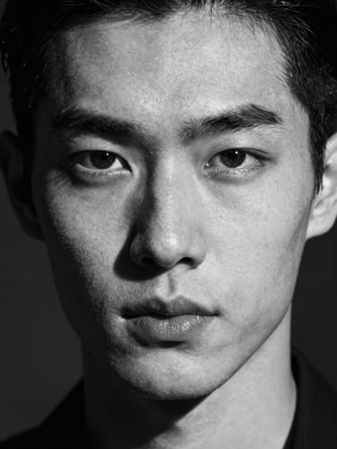 Stark black and white studio portrait of a model with sharp, angular facial features, harsh direct strobe lighting casting a deep shadow on one side, unretouched skin texture, neutral expression, extreme close-up.