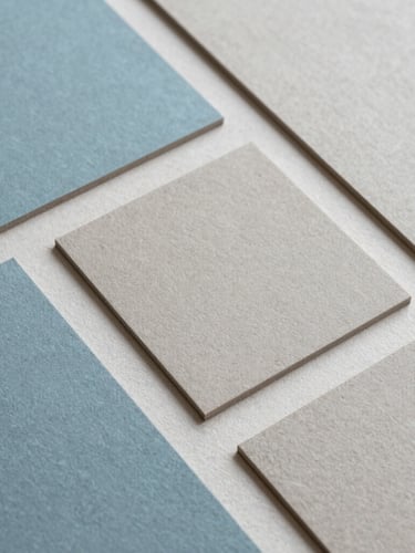 Overhead flat lay of tactile design materials, textured heavy paper stocks, muted cerulean and warm stone gray swatches under soft diffused daylight, minimalist 35mm composition