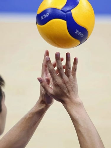 Close-up of a young athlete's hands locked in a clean passing platform, making solid contact with a volleyball, bright indoor court background.