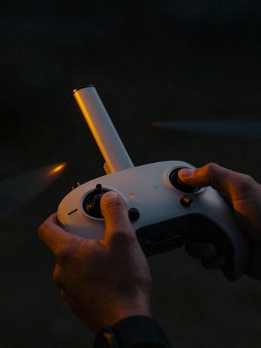 Cinematic close-up of a drone controller and hands in low-key lighting, deep obsidian shadows, sharp neon-amber accents, shallow depth of field.