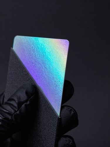 Extreme macro studio photograph of a pristine holographic card corner held by hands in matte-black sleeves, dramatic side-lit cyan and violet neon glow, deep obsidian background