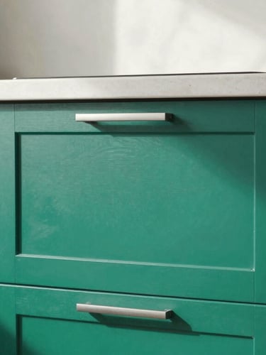 Close-up of a modern kitchen renovation with sharp emerald accents, clean lines, professional carpentry work, natural daylight
