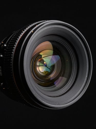 Cinematic medium shot of a camera lens element floating in dark space, light refracting through glass layers, subtle gold dust particles, deep black background
