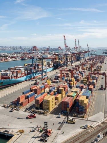 Wide-angle architectural shot of a modern cargo port at daylight, clean container ships, high clarity