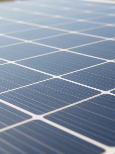 Close-up macro photography of high-purity silicon solar cells catching bright natural daylight, clean geometric grid lines, technical precision.