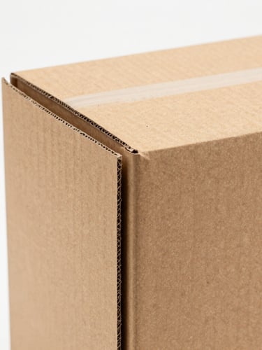 Macro shot of a heavy-duty cardboard packaging box designed for vinyl records, showing thick protective multi-layer edges on a clean white studio background