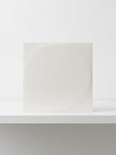 Straight-on orthographic studio shot of a pristine 7-inch vinyl compact sleeve resting on a sterile white metal shelf, sharp focus, bright even lighting