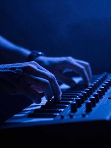 Moody close-up of hands adjusting an analog synthesizer knob under high-contrast blue club lighting, 35mm film grain, atmospheric smoke, dark background