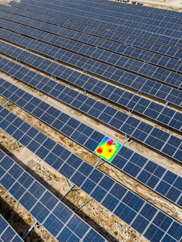 Wide aerial drone shot of a massive industrial solar array in Cordoba, high-contrast daylight, technical overlay showing a thermal heat signature hotspot on one panel, sharp 35mm.